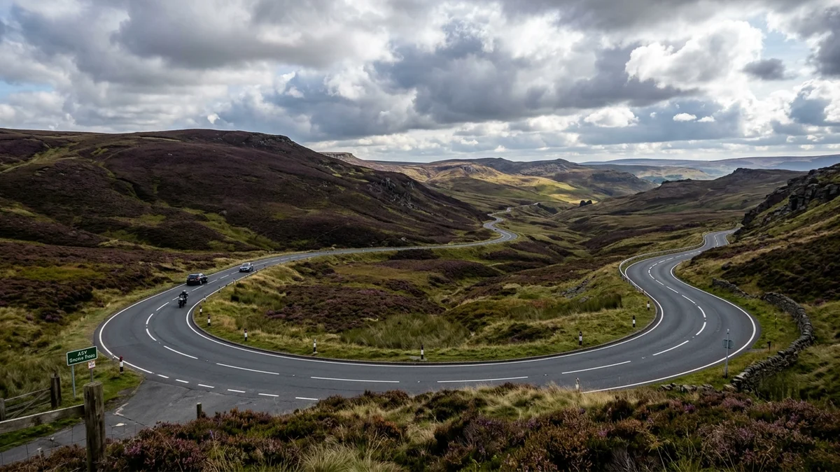 Scenic curves of the A57 Snake Pass winding through Peak District heather moorland in Derbyshire